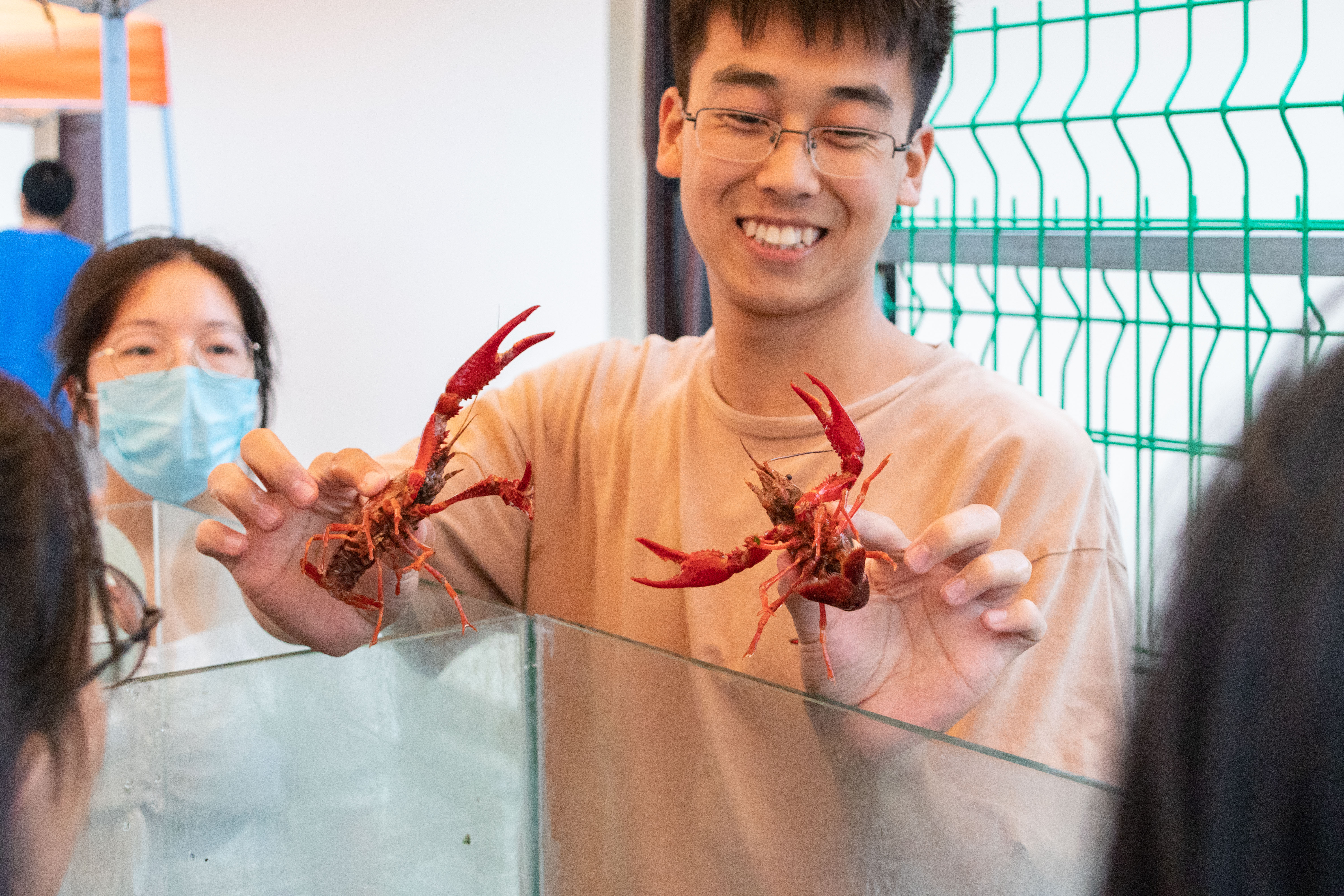 澳门威斯尼斯wns88819级研究生杨伟杰向新生讲解如何辨别小龙虾雌雄（学通社记者 周丹丹 摄）